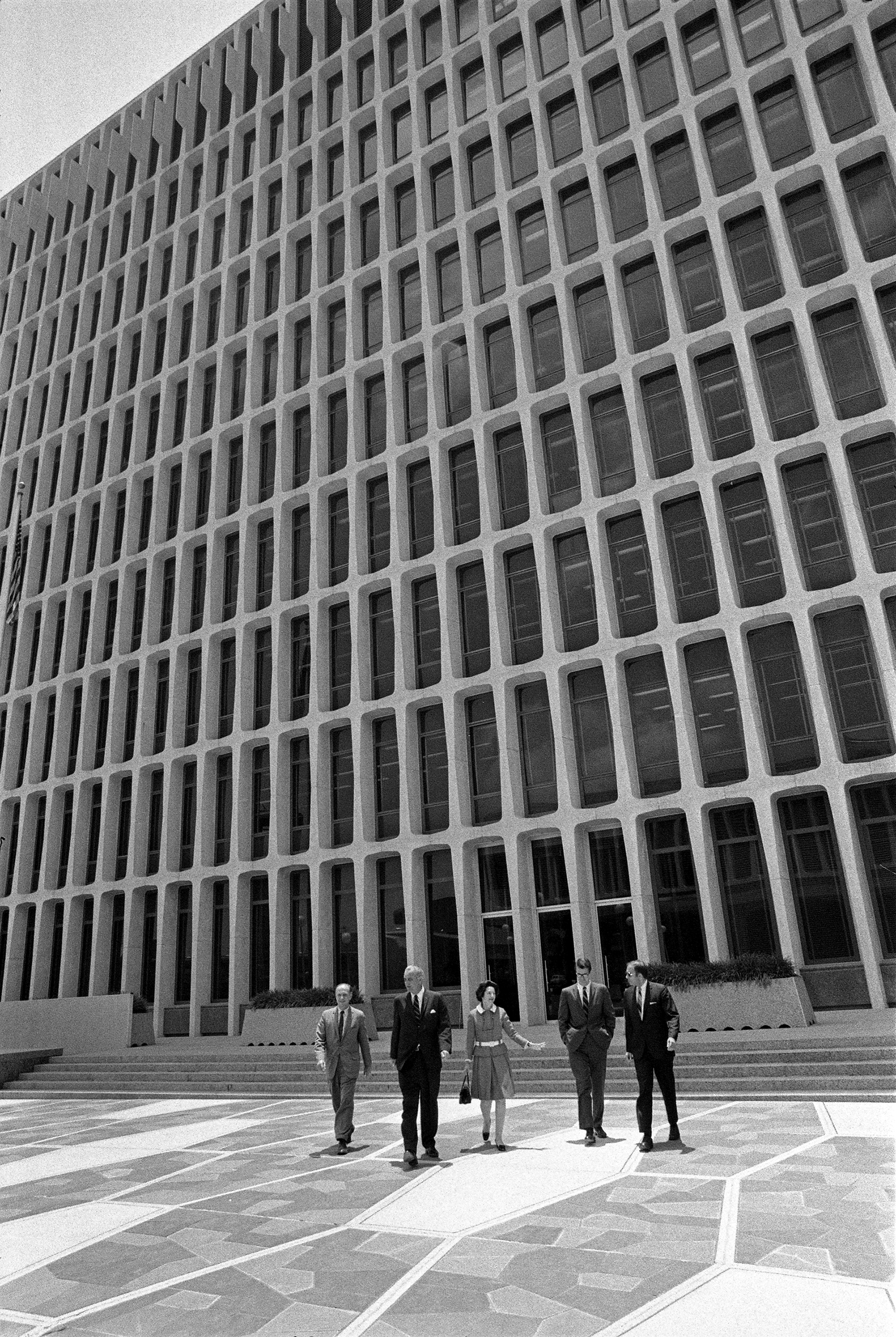 President Lyndon B. Johnson, Lady Bird Johnson, Tom Johnson, Harry Middleton in front of a modern building.
